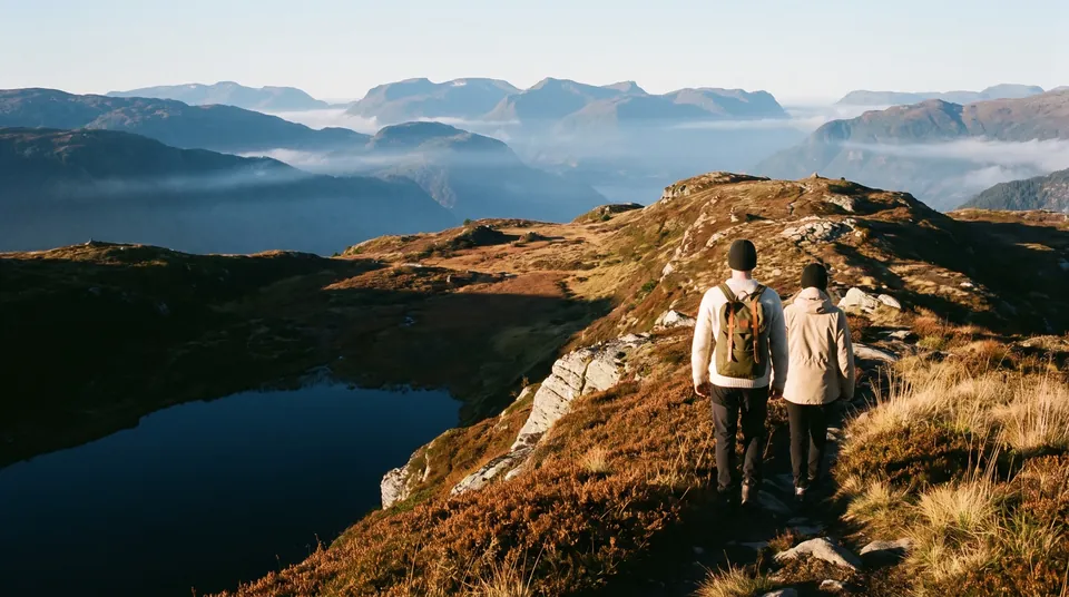 Two hikers on a mountain ridge in evening light